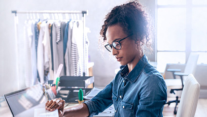 A businesswoman sitting in her office and reviewing documents.