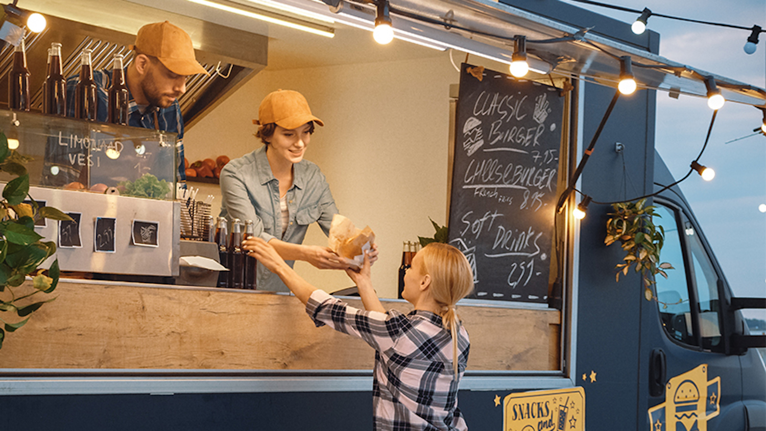 Partners in a food truck prepare an order for a customer. Some business owners decide to create a corporation or an LLC and do the name searching as the business grows.