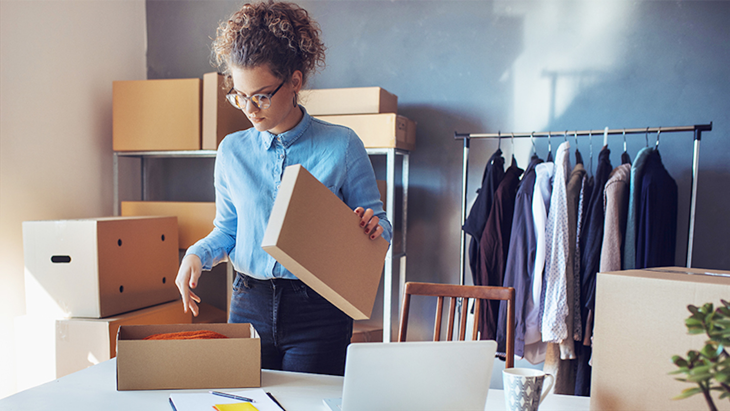 A fashion stylist prepares boxes of clothing to be shipped and considers what kind of business entity to form.. LLC status works well for most industries, except banking and insurance, which the state prohibits.