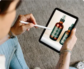 woman wearing a white collard shirt, jeans and grey sneakers sitting in a chair working on her essential oils business after forming her LLC with LegalZoom.