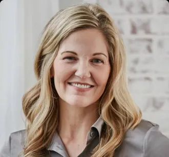 Allison Howard, a White woman with long blonde hair wearing grey collared shirt smiling after winning a business grant from LegalZoom's Fast Break for Small Business.